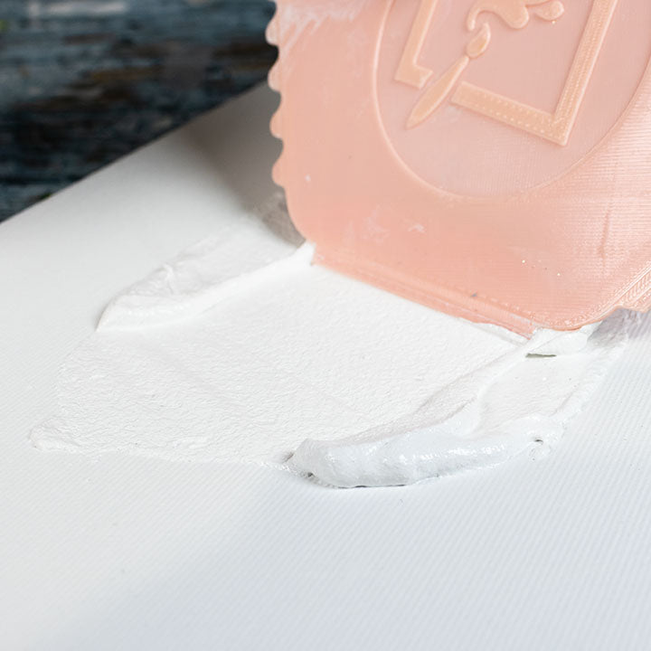 Applying ARTMiE 3D Relief Paste to a canvas with a scraper