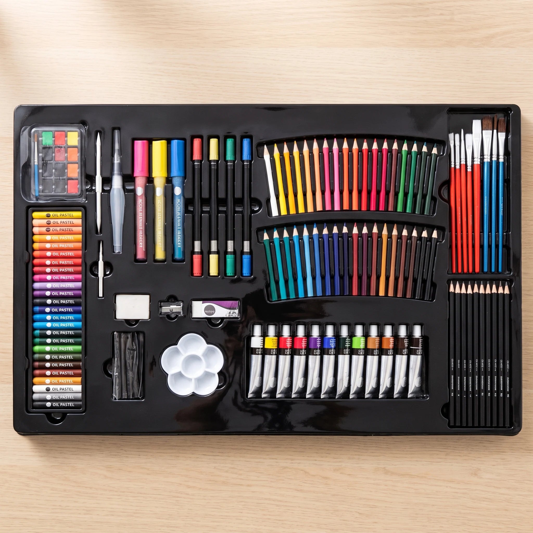 Black plastic tray from an art set with 215 supplies in shaped compartments