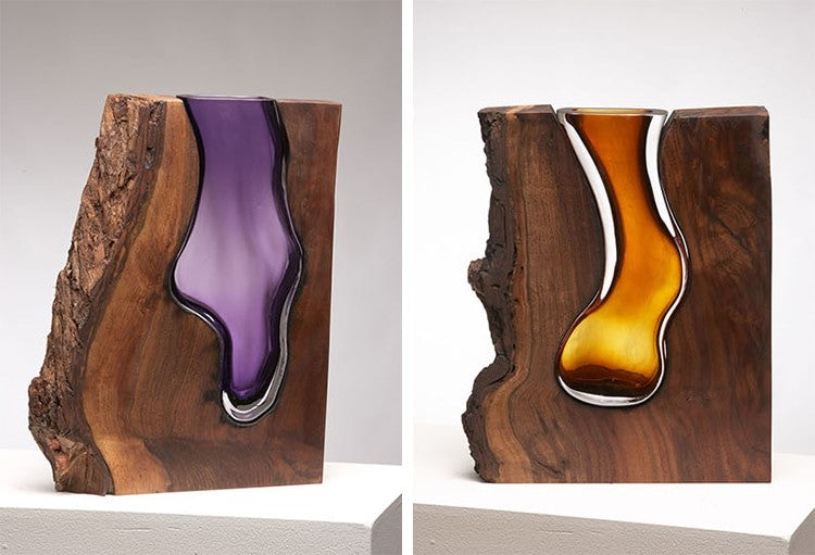 Prachtige glazen sculpturen in boomstammen
